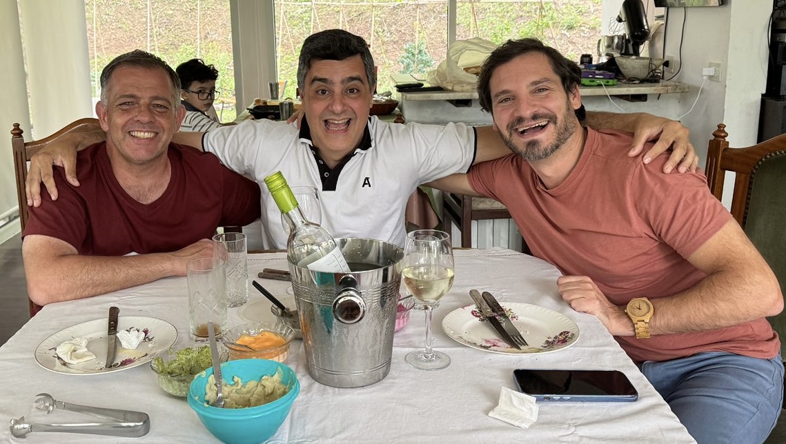 Alberto con sus amigos Miguel y Tano alrededor de una mesa