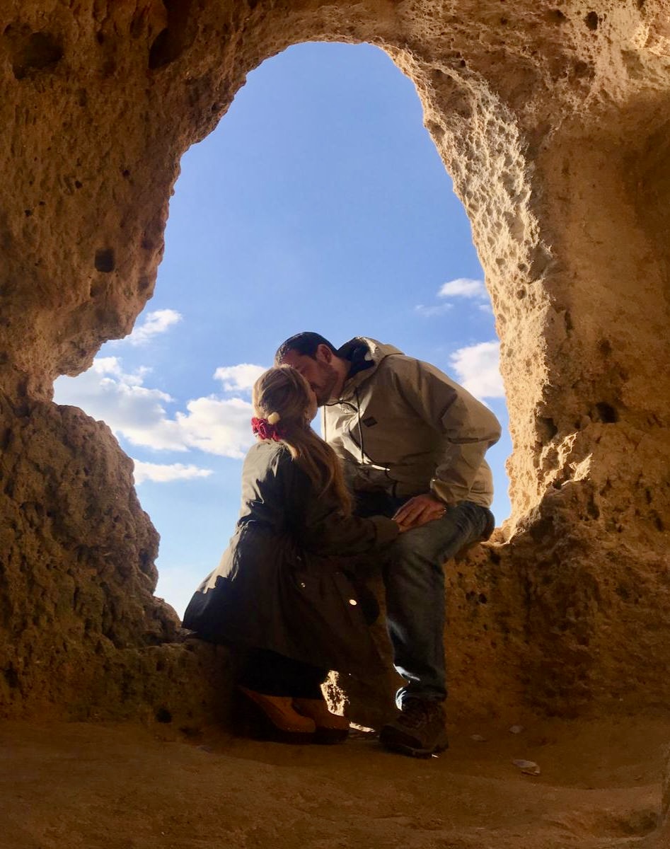 Alberto besa a su pareja bajo un arco de piedra en Faro