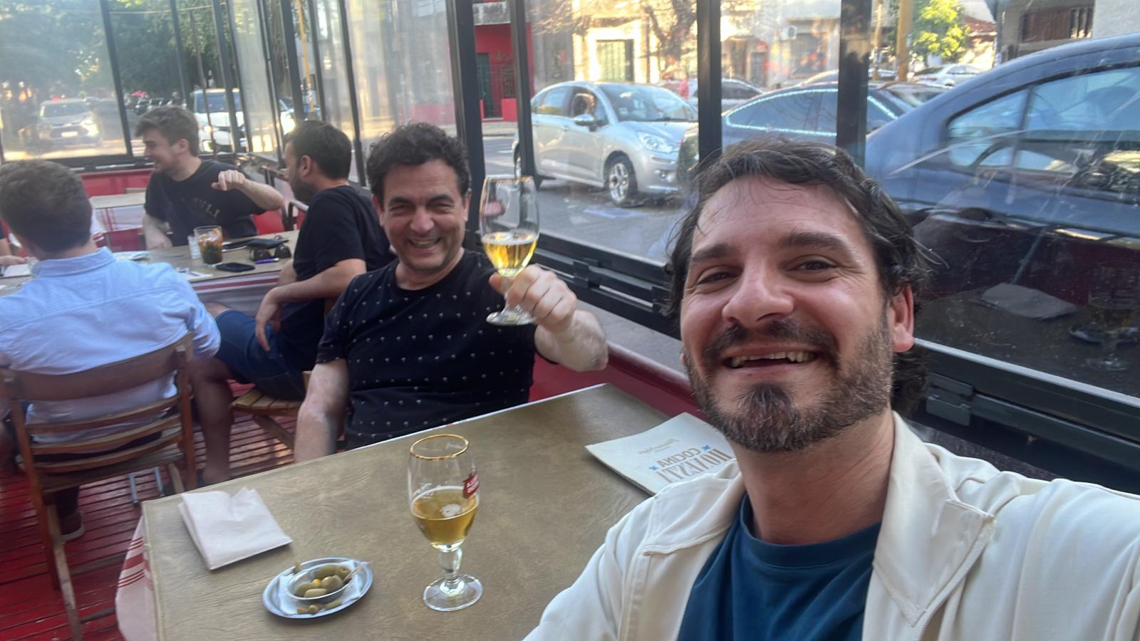 Alberto y Marcelo conversando en una mesa al aire libre