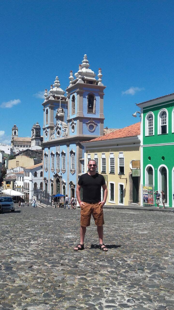 Alberto en una calle empedrada del Pelourinho, frente a edificios coloniales